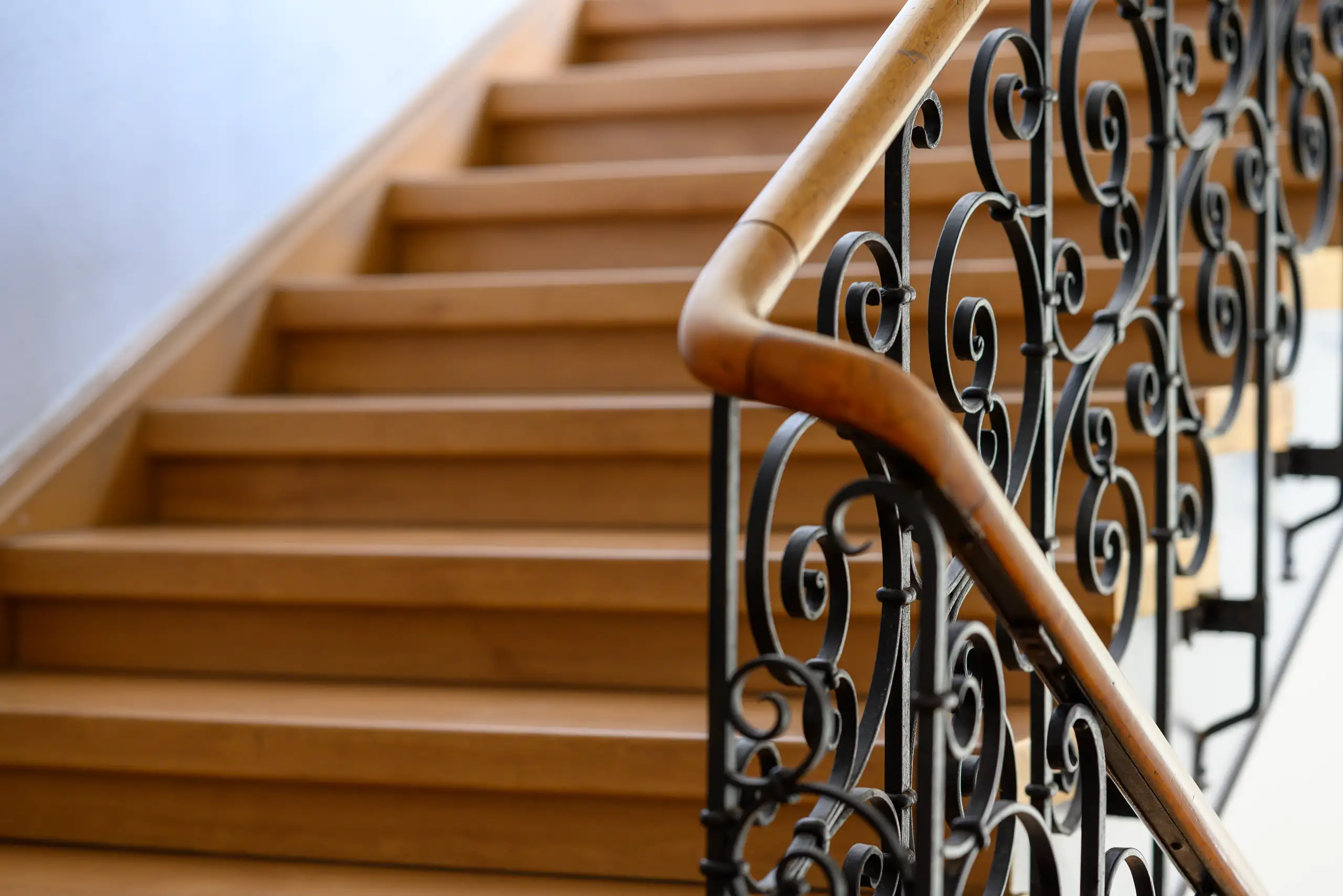 Schody policzkowe z drewnianymi stopniami i metalową balustradą